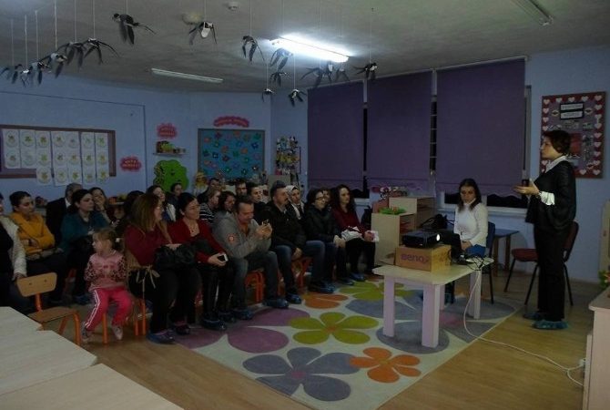 Çocukları anaokuluna devam eden veliler, çocuklarının oturdukları sandalyelerde oturarak eğitim