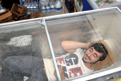 Sıcaktan bunalan esnaf dondurma dolabında serinliyor