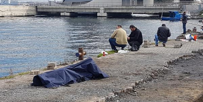 Cesede rağmen balık tutmaya devam ettiler