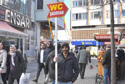 Sevdiği kız için hergün ‘WC-Şadırvan’ tabelasını tutuyor