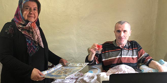 Yatağa mahkum eşine bakıyor