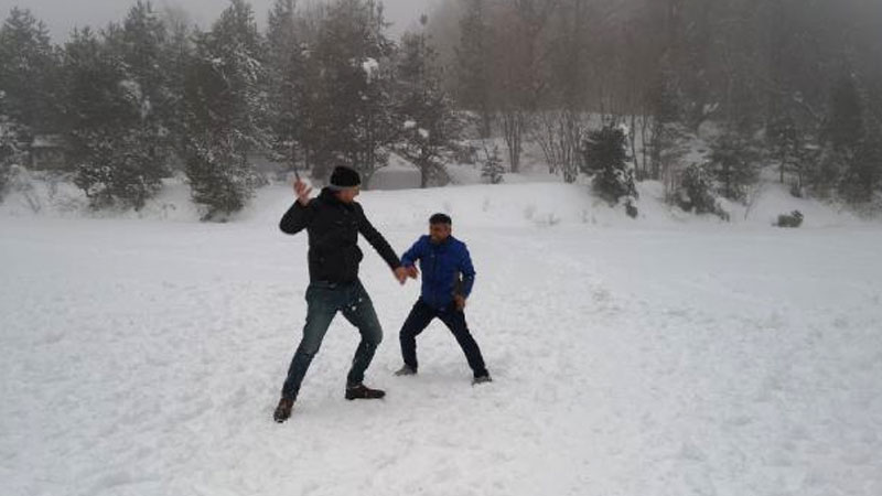 Buz tutan göletin üzerinde kar topu oynadılar