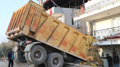 Freni boşalan hafriyat kamyonu duvarda asılı kaldı