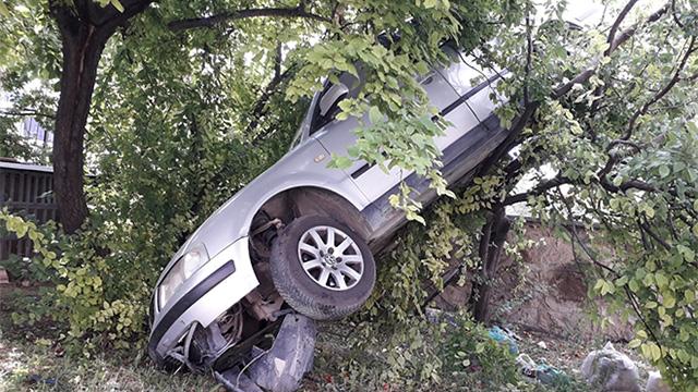 Kaza yapan otomobil ağaçta asılı kaldı