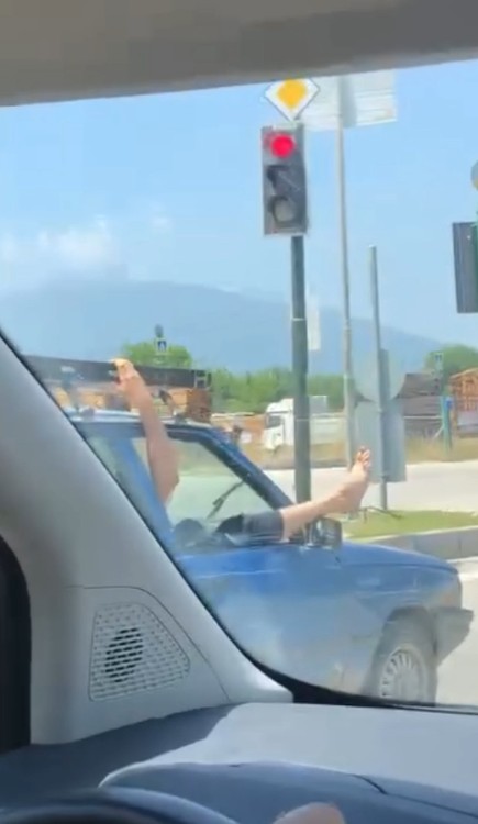 Bursa trafiğinde ilginç anlar! Görenler hayrete düştü… Bursa'nın İnegöl ilçesinde seyir halindeki otomobilin camından ayaklarını çıkarıp, içki